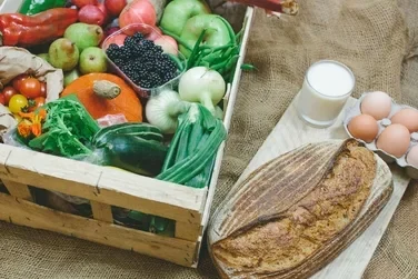 Organic fruit and Veg Box example with freshly baked bread, organic eggs and a glass of organic milk.